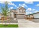 Two-story house with gray siding, a two-car garage, and landscaping at 9374 Bahama Ct, Commerce City, CO 80022