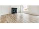 Bright living room featuring a modern fireplace and wood-look floors at 9374 Bahama Ct, Commerce City, CO 80022