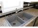 Modern double kitchen sink with granite countertop and gray tile backsplash at 16163 Barley Ave, Fort Lupton, CO 80621