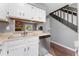 Clean kitchen featuring white cabinetry, stainless steel dishwasher, and a stone fireplace at 8140 S Fillmore Cir, Centennial, CO 80122