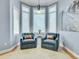 Bright sitting room with two comfy armchairs, a small table, and plenty of natural light at 9022 Jason Ct, Boulder, CO 80303