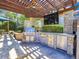 Outdoor kitchen with stainless steel appliances under pergola at 9022 Jason Ct, Boulder, CO 80303