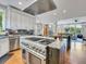 Modern kitchen features a huge island with cooktop, stainless steel appliances, and open concept to Gathering room at 9022 Jason Ct, Boulder, CO 80303