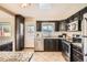 Updated kitchen with dark cabinetry, granite counters, and stainless steel appliances at 3390 Teller St, Wheat Ridge, CO 80033