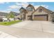 Two-story home with stone exterior, two-car garage, and landscaped yard at 7032 S Waterloo Way, Aurora, CO 80016