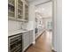 Butler's pantry with wine cooler, sink, and glass-front cabinets at 7032 S Waterloo Way, Aurora, CO 80016