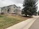 Two-story house with gray siding, landscaping, and a tree at 9711 Millstone Ct, Highlands Ranch, CO 80130