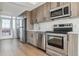 Modern kitchen with stainless steel appliances and wood cabinets at 3575 Chestnut Pl # 606, Denver, CO 80216