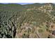 Aerial view of house on a wooded mountainside at 22759 Mountain Spirit Way, Indian Hills, CO 80454