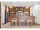 Custom wet bar with wooden cabinetry and seating at 22759 Mountain Spirit Way, Indian Hills, CO 80454