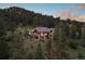 Backyard view of home showcasing large deck and mountain views at sunset at 22759 Mountain Spirit Way, Indian Hills, CO 80454