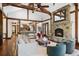 Spacious living room with exposed beams, stone fireplace, and hardwood floors at 22759 Mountain Spirit Way, Indian Hills, CO 80454