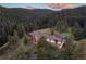 Luxury home nestled in a wooded, mountainous area with stunning sunset views at 22759 Mountain Spirit Way, Indian Hills, CO 80454
