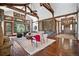Open living space with high ceilings, exposed beams, stone fireplace and hardwood floors at 22759 Mountain Spirit Way, Indian Hills, CO 80454