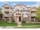 Beige three-story condo building with balconies and landscaping at 5703 N Gibralter Way # 204, Aurora, CO 80019