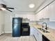 Modern kitchen with white cabinets, granite counters, and black appliances at 9380 W 49Th Ave # 108, Wheat Ridge, CO 80033