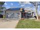 Two-story house with gray siding, solar panels, and a red door at 12195 Grape St, Thornton, CO 80241