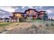 Luxury home exterior with stone accents and expansive windows at dusk at 24503 Chris Dr, Evergreen, CO 80439