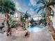 Indoor pool oasis with waterfall feature, lush landscaping, and palm trees at 24503 Chris Dr, Evergreen, CO 80439