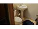 Small pedestal sink and toilet in a well-lit bathroom at 8120 S Jay Dr, Littleton, CO 80128