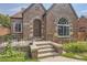 Brick home with a charming front porch and intricate metal gate at 1460 Tennyson St, Denver, CO 80204