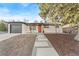 Remodeled Ranch home features a modern gray and white exterior, landscaping, and red door at 195 Jade St, Broomfield, CO 80020