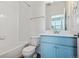 Bathroom with blue vanity, white tiled shower, and light wood-look flooring at 6940 Merseyside Ln, Castle Pines, CO 80108