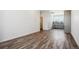Living room with wood-style flooring, white walls, and view of the kitchen at 6940 Merseyside Ln, Castle Pines, CO 80108