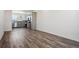 Living room with wood-style flooring, showcasing an open layout and a glimpse of the modern kitchen at 6940 Merseyside Ln, Castle Pines, CO 80108