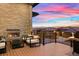 Spacious deck with a built-in fireplace and seating area, offering scenic views at 1196 Lost Elk Loop, Castle Rock, CO 80108