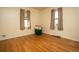 Simple bedroom with hardwood floors and two windows at 7261 Magnolia St, Commerce City, CO 80022