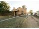 A beige ranch house with a gravel driveway and chain link fence at 7261 Magnolia St, Commerce City, CO 80022