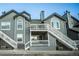 Exterior view of a gray townhouse with a deck and stairs at 8341 S Upham Way # 105, Littleton, CO 80128