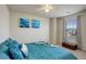 Spacious bedroom with teal bedding and a view from the window at 16730 Race Ct, Thornton, CO 80602