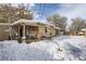 Snowy backyard with patio, shed, and mature trees at 1240 S Chase Ct, Lakewood, CO 80232