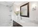 Bright bathroom with a vanity, marble countertop, and framed mirror at 1452 S Vine St, Denver, CO 80210