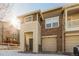 Two-story townhome with tan and brown exterior and a two-car garage at 13043 Grant Cir # C, Thornton, CO 80241