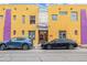 Bright yellow building exterior with purple accents and parking at 910 Santa Fe Dr # 19, Denver, CO 80204