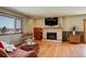 Cozy living room features a fireplace, hardwood floors, and large windows with a view at 9350 Grandview Ave, Arvada, CO 80002