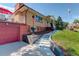 House exterior showcasing steps, landscaping, and a red garage door at 9350 Grandview Ave, Arvada, CO 80002