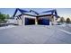 Two-car garage with modern black doors and a large concrete driveway at 1571 Arrowpoint Ct, Franktown, CO 80116