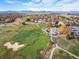 Aerial view of a golf course community with mountain views and fall foliage at 4340 Nelson Dr, Broomfield, CO 80023