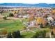 Aerial view of homes and a golf course with fall colors and mountain backdrop at 4340 Nelson Dr, Broomfield, CO 80023