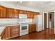 Bright kitchen with wood cabinets, white appliances, and laminate flooring at 12565 Sheridan Blvd # 202, Broomfield, CO 80020