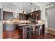 Modern kitchen with dark wood cabinetry, granite countertops, and stainless steel appliances at 7600 Landmark Way # 1215, Greenwood Village, CO 80111