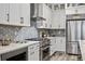 Modern kitchen with white cabinets, stainless steel appliances, and hexagon backsplash at 3010 Newfound Lake Rd, Berthoud, CO 80513
