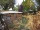 Small brick shed in need of repair, located in a grassy backyard at 230 Emery St, Longmont, CO 80501
