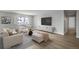 Living room featuring light colored furniture, a large TV, and hardwood floors at 3465 S Poplar St # 308, Denver, CO 80224