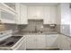 White kitchen with granite countertops and a double sink at 3465 S Poplar St # 308, Denver, CO 80224
