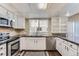 Modern kitchen featuring white cabinets and granite countertops at 1050 S Monaco Pkwy # 7, Denver, CO 80224